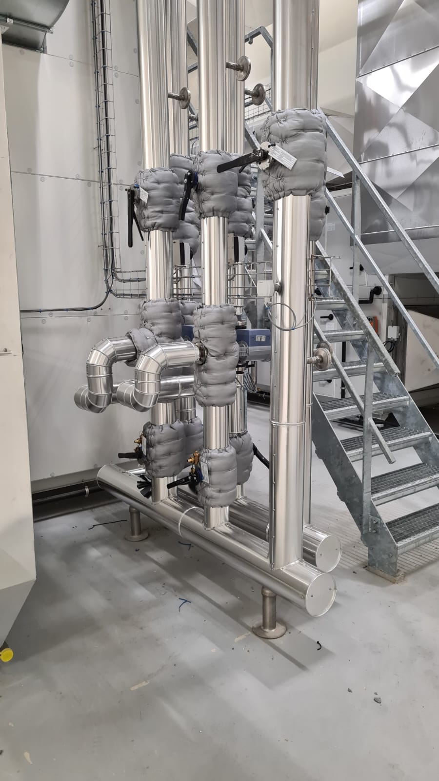 CV-verdeler met aluminium ommantelde leidingen en grijze isolatiekappen rond de afsluiters