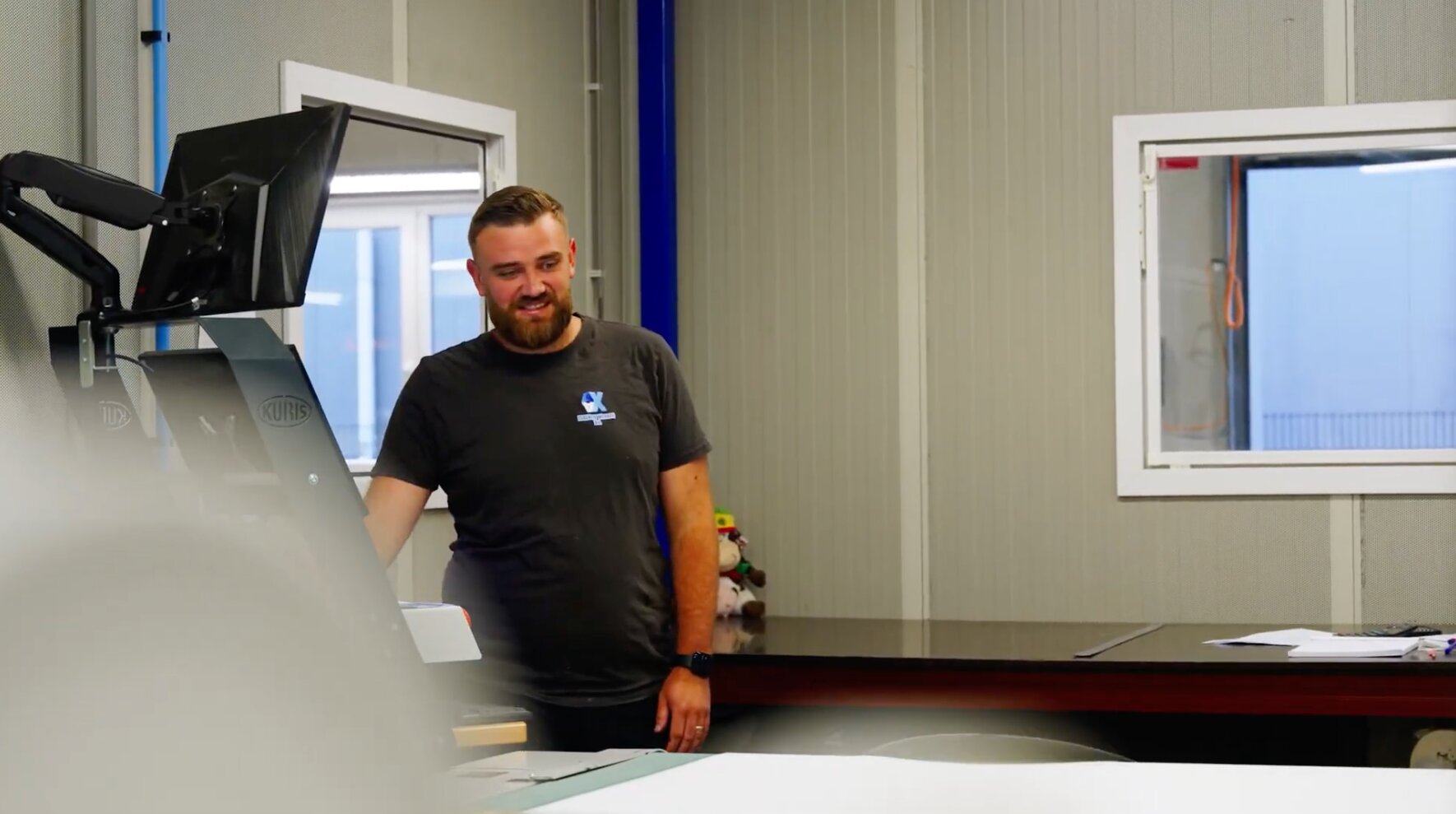 Medewerker van AX Isolatiewerken aan het werk bij een snijmachine in de werkplaats