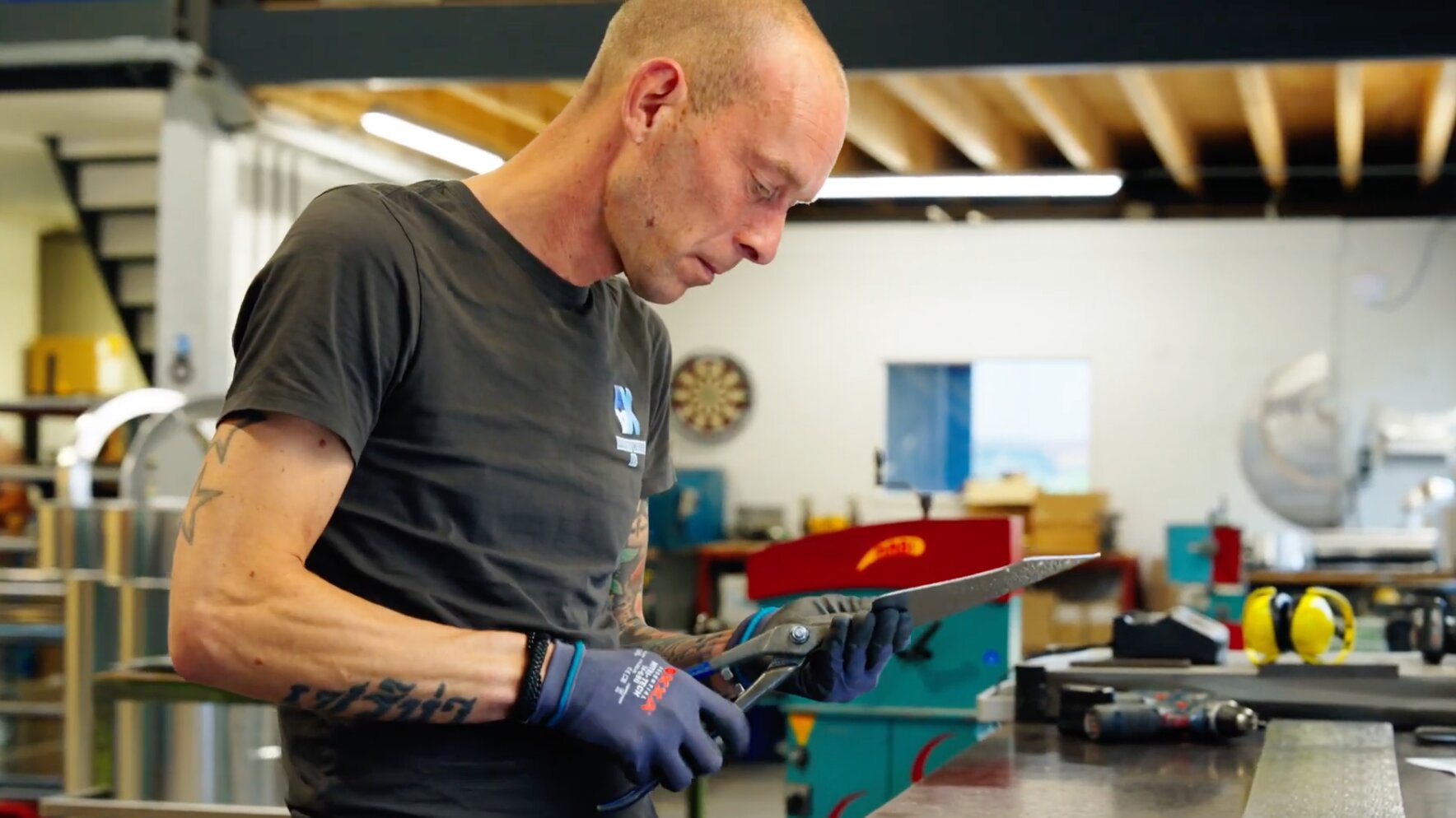 Medewerker van AX Isolatiewerken knipt plaatwerk op maat met een plaatschaar